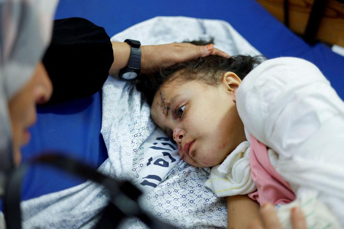 Palestinian girl Fulla Al-Laham, 4, who was wounded in an Israeli strike that killed 14 family members, including her parents and all her siblings, lies on a bed as her grandmother sits next to her, at a hospital in Khan Younis in the southern Gaza Strip. — Reuters