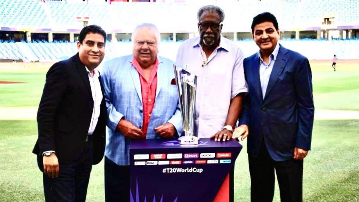(From left) Boria Majumdar, Farokh Engineer, Clive Lloyd and Ajay Sethi, Chairman and MD of the Channel 2 Group Corporation, pose with the ICC T20 World Cup trophy at the Dubai International Cricket Stadium. (Supplied photo)