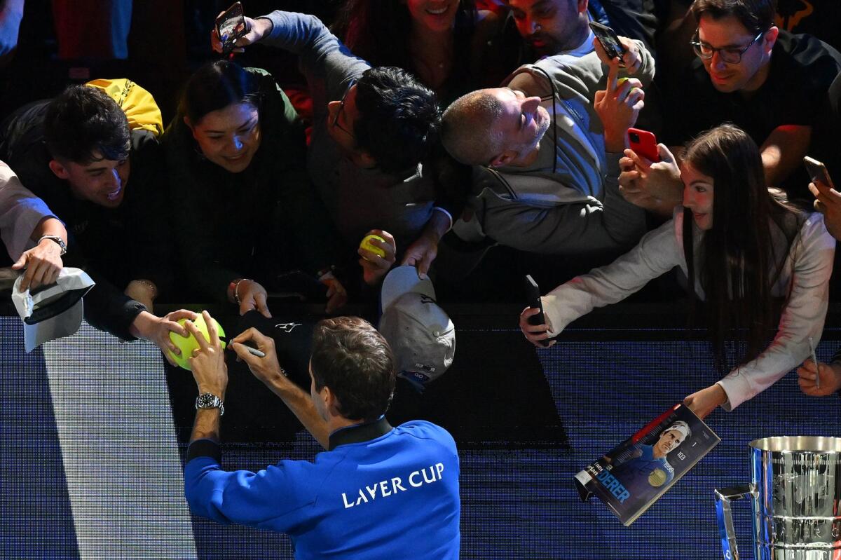 Roger Federer signs autographs for fans at the O2 Arena in London on Friday. (AFP)
