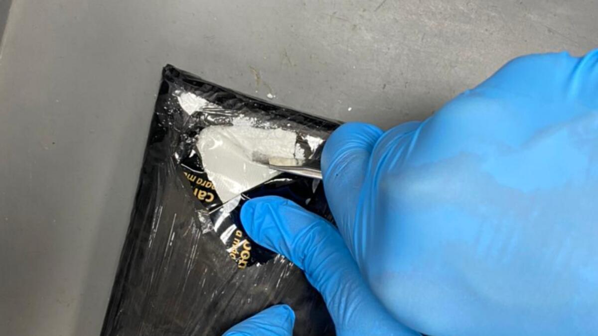 Dubai Customs officers reveal the secret pocket of a passenger's suitcase where 3.2kg of cocaine was hidden. — Wam