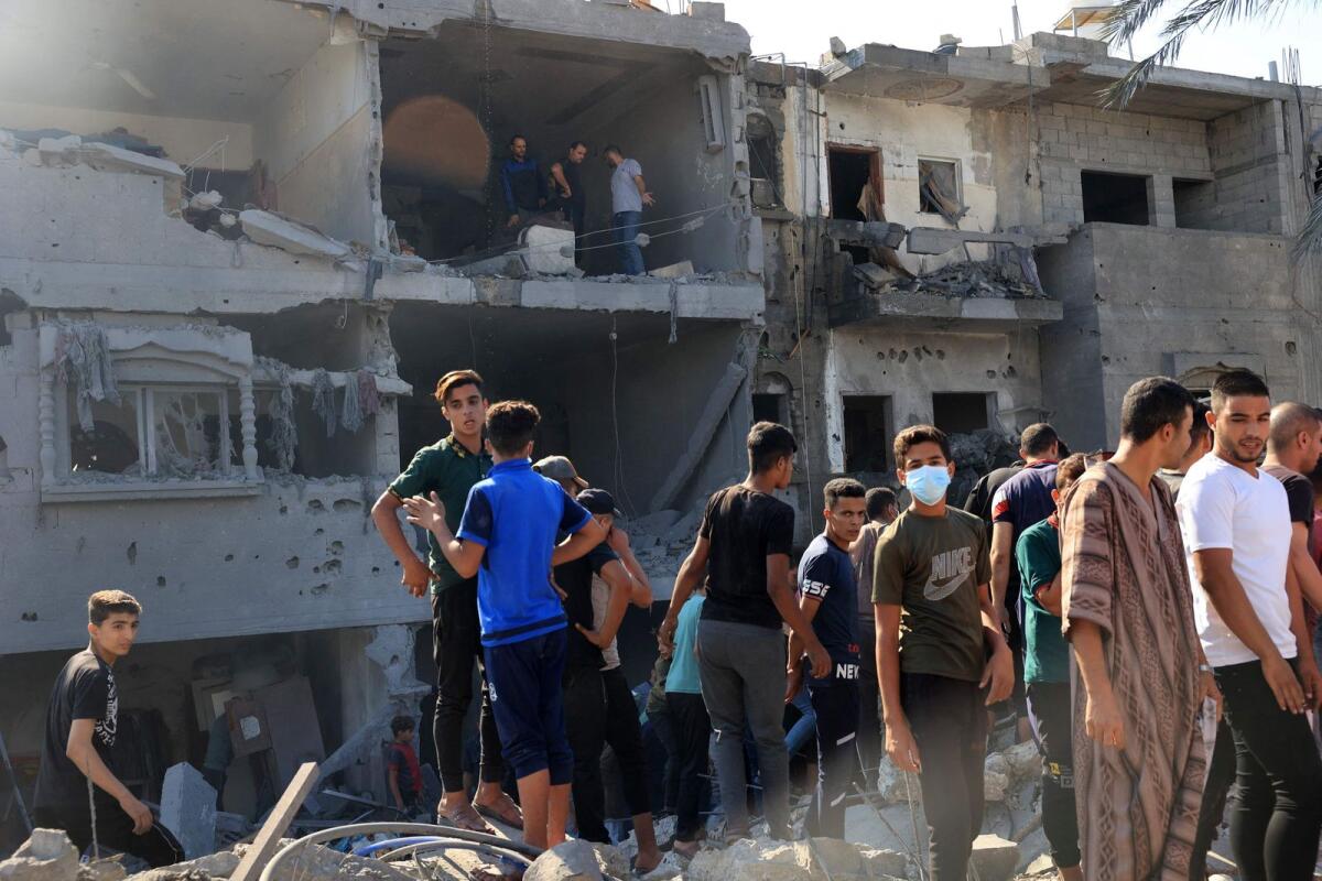 Palestinians gather at the site of a collapsed and damaged buildings following an Israeli airstrike in Rafah, in the southern of Gaza Strip, on October 16, 2023. Photo: AFP