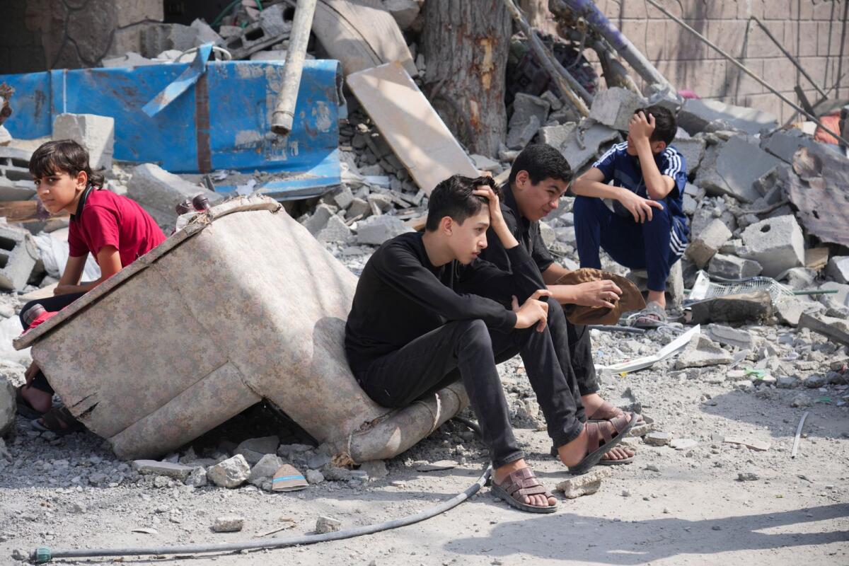 Palestinian boys sit on the rubble of a building destroyed in an Israeli airstrike in Nuseirat camp in the central Gaza Strip on Monday, Oct. 16, 2023. Photo: AP