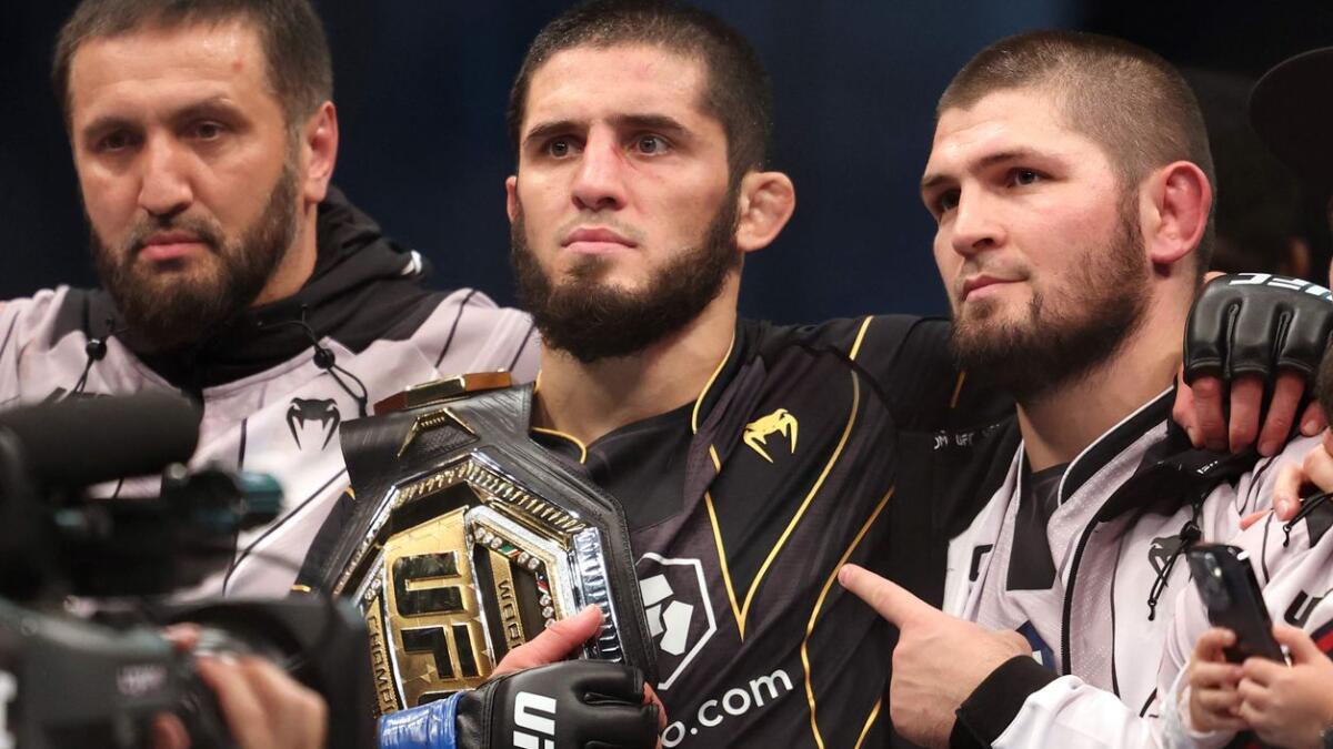 Islam Makhachev (2nd-C) poses for a picture with his coach Khabib Nurmagomedov (R) . - AFP File
