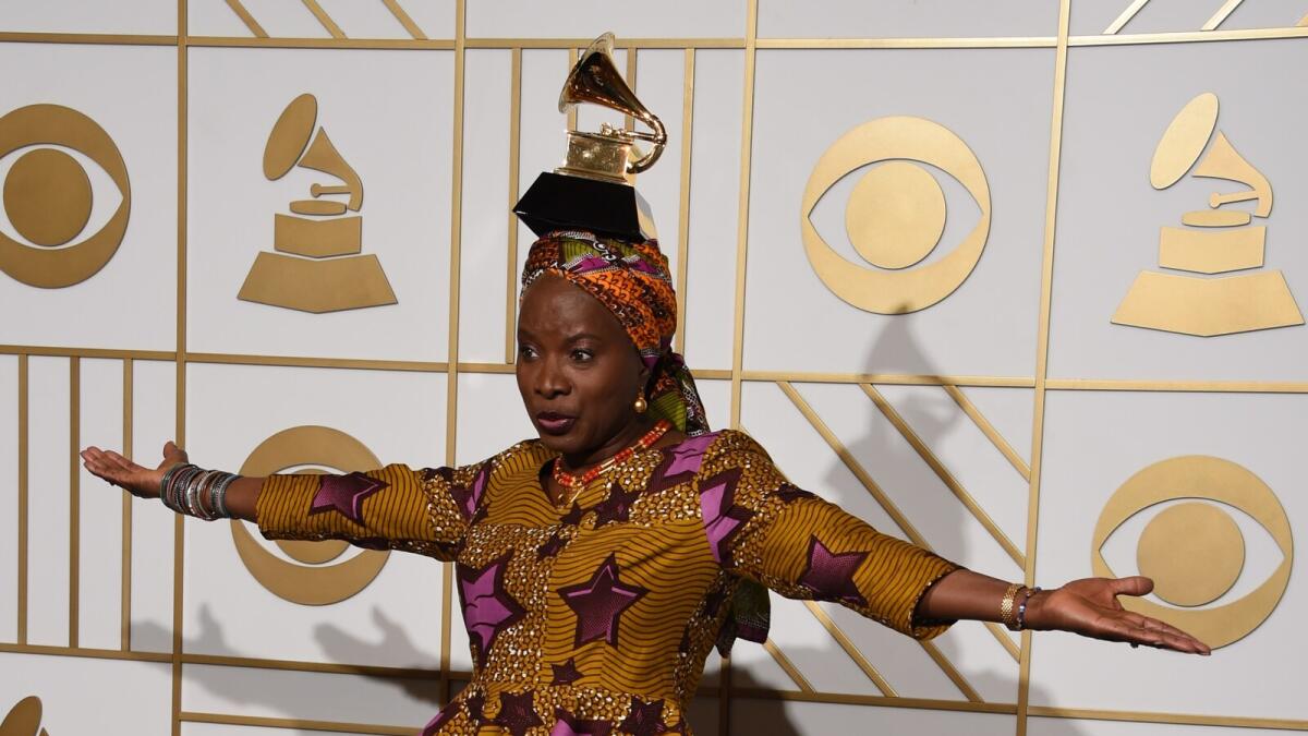 Angelique Kidjo poses with her Best World Music Album trophy for 'Sings' in the press room during the 58th Annual Grammy Music Awards in Los Angeles on February 15, 2016.