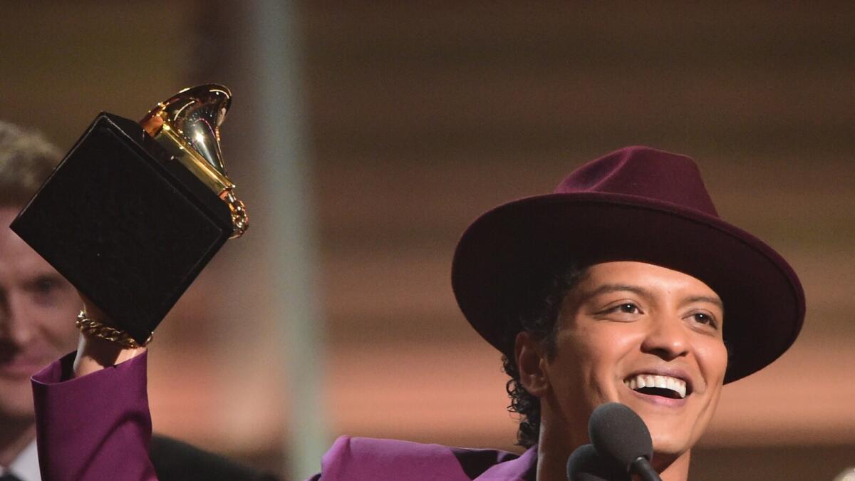 Singer Bruno Mars holds up the award for the Record of the Year, Uptown Funk onstage during the 58th Annual Grammy music Awards in Los Angeles February 15, 2016.