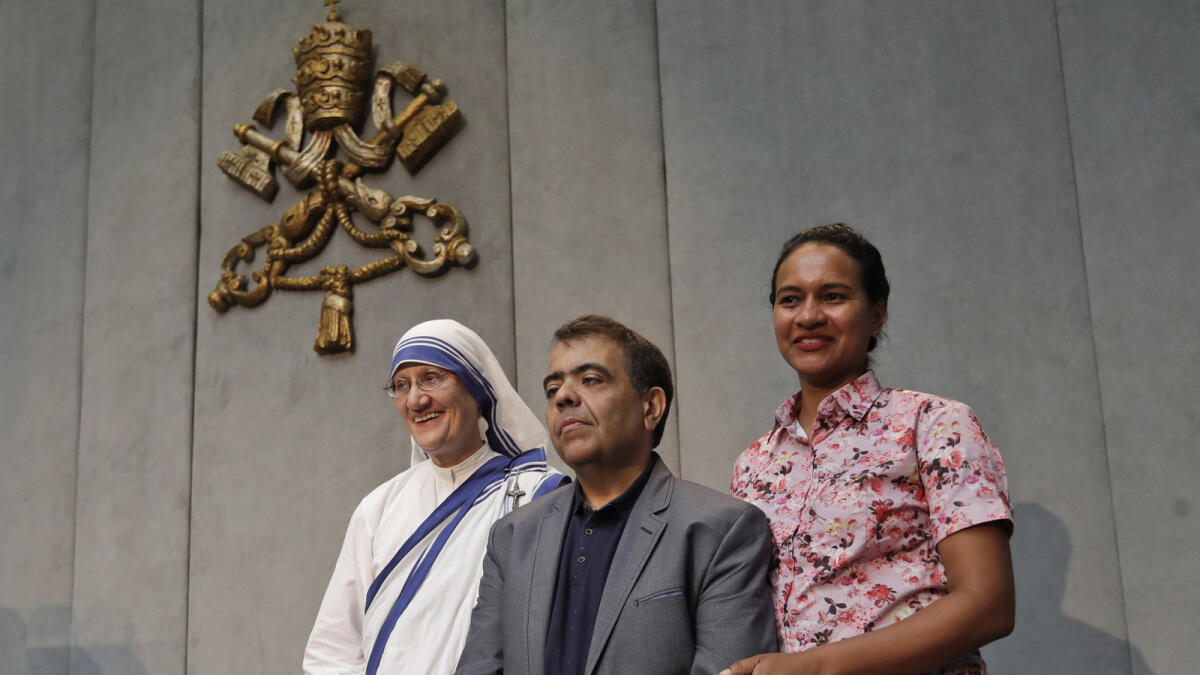 From left, Sr. Mary Prema Pierick, Superior General of the Missionaries of Charity, Marcilio Andrino, center and his wife Fernanda Nascimento Rocha pose for photographers at the end of a press conference at the Vatican, Friday, Sept. 2, 2016. Andrino's cure of a viral brain infection, declared a miracle by Pope Francis earlier this year, was the final step needed to declare Mother Teresa a saint. (AP Photo/Alessandra Tarantino)