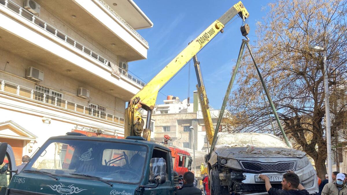 A crane lifts a damaged car near a site that was hit by an Israeli strike in the Mazzeh neighborhood of Damascus. — Reuters