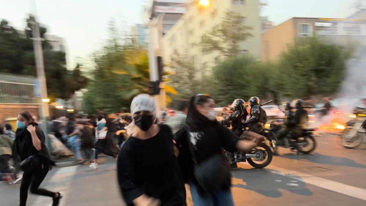 Women run away from anti-riot police during protests in downtown Tehran. – AP