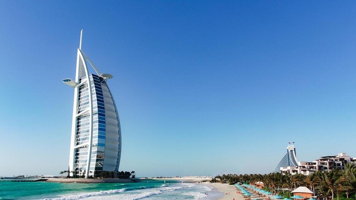 Tourists at a beach overlooking the Burj Al Arab hotel in Dubai. The UAE's non-oil GDP is likely to continue growing, driven by the performance of the hospitality, real estate, and financial services sectors. — File photo