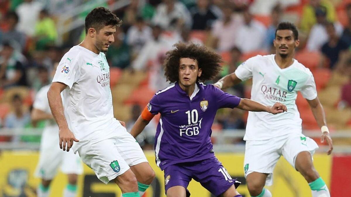 Al Ain’s Omar Abdulrahman defends against Al Ahli’s Marco Antoinio (left) during their AFC Champions League match.