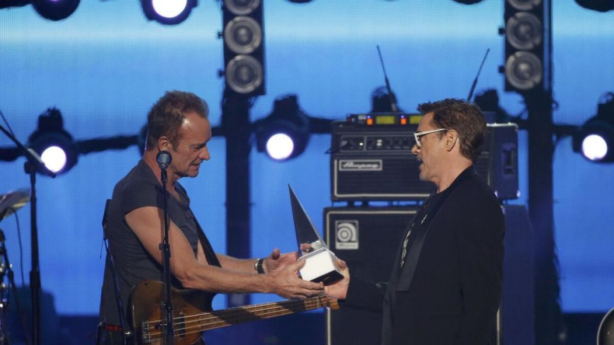 Actor Robert Downey Jr. (R) presents Sting with the American Music Award of Merit.- Reuters