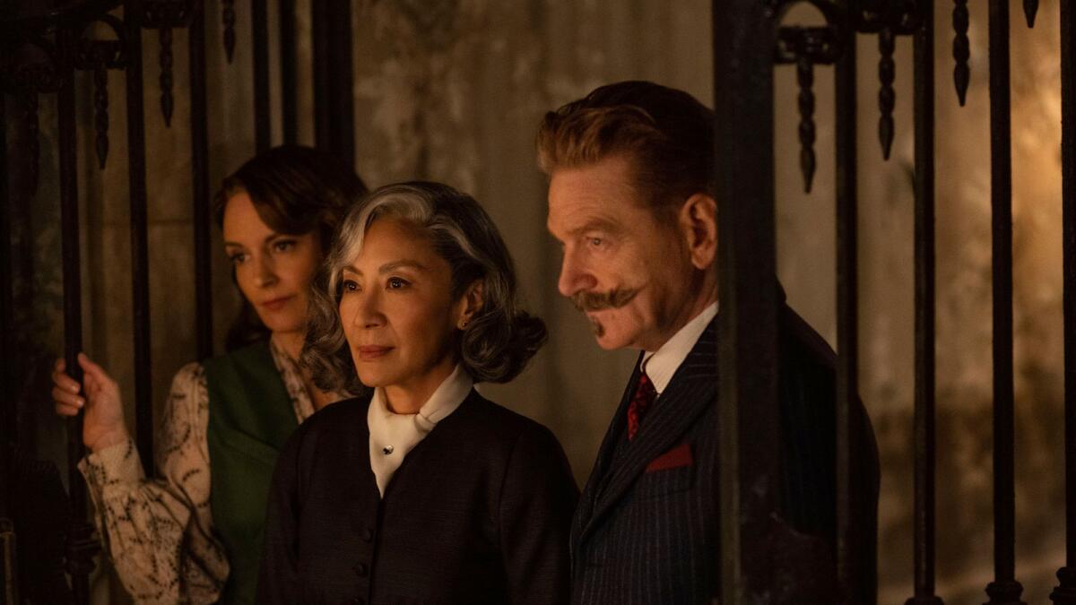 From left, Tina Fey as Ariadne Oliver, Michelle Yeoh as Mrs. Reynolds, and Kenneth Branagh as Hercule Poirot in a scene from 'A Haunting in Venice'