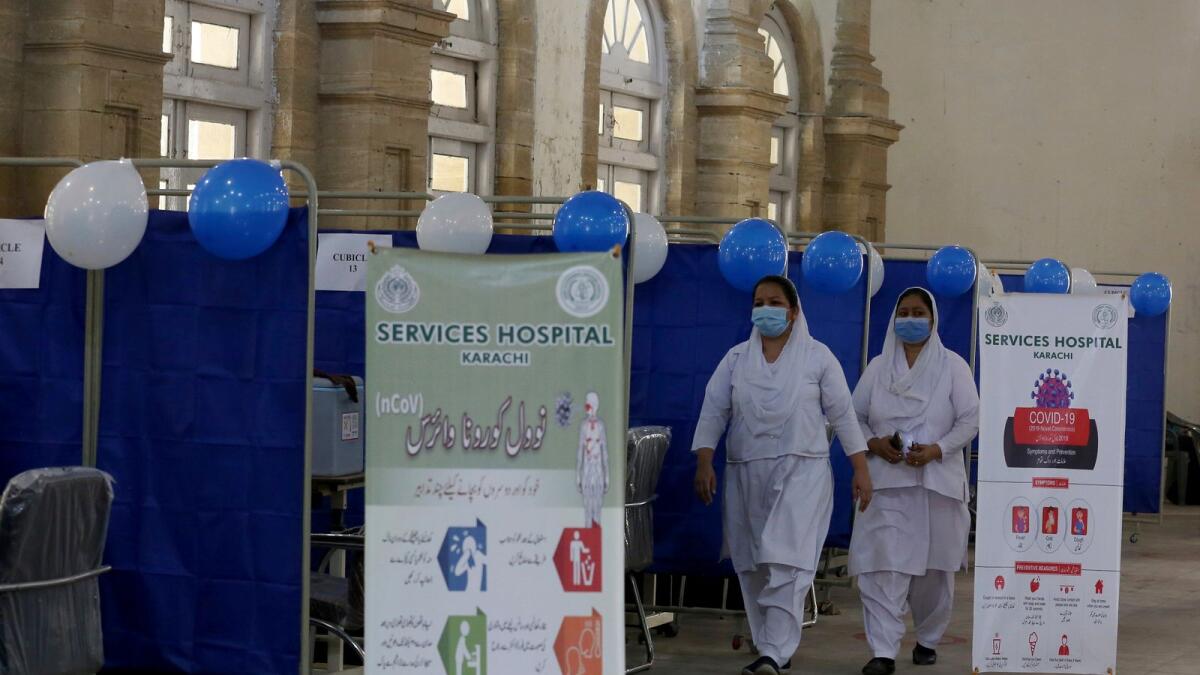 Nurses walk in a centre newly set up for upcoming Covid-19 vaccination in Karachi on Saturday.