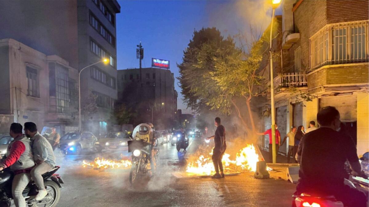 Protestors set fire to objects in Tehran. — AFP