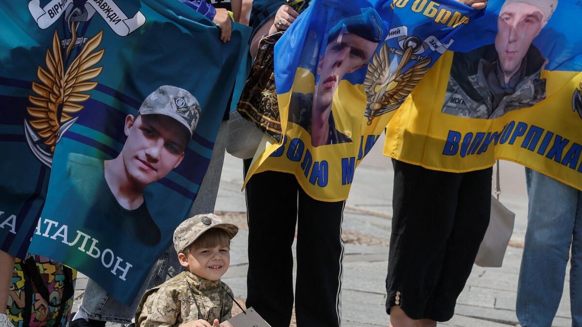 A young boy dressed in a military uniform holds a banner with the inscription 'Bring back my brother' as relatives of Ukrainian Marines, who defended the Azovstal and are prisoners of war, hold banners as they attend a rally calling for authorities to return their relatives from Russian captivity. — Photo: Reuters
