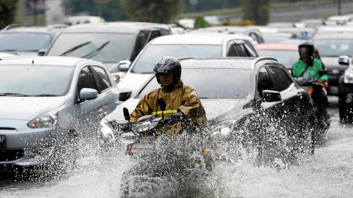 Motorists make their way through a flooded section of a road after heavy rains hit central Jakarta, Indonesia August 30, 2016. Reuters
