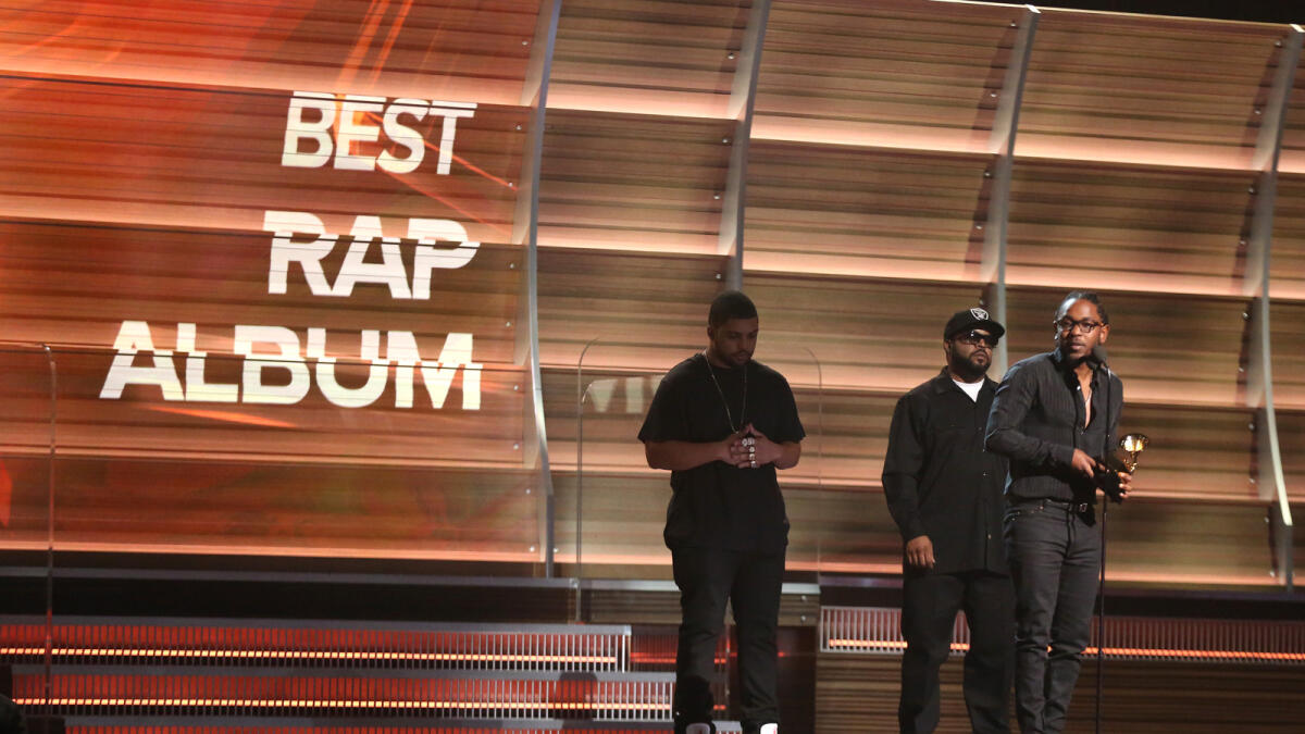 'Shea Jackson Jr., left, and Ice Cube look on from left as Kendrick Lamar accepts the award for best rap album for 'To Pimp A Butterfly' at the 58th annual Grammy Awards on Monday, Feb. 15, 2016, in Los Angeles.