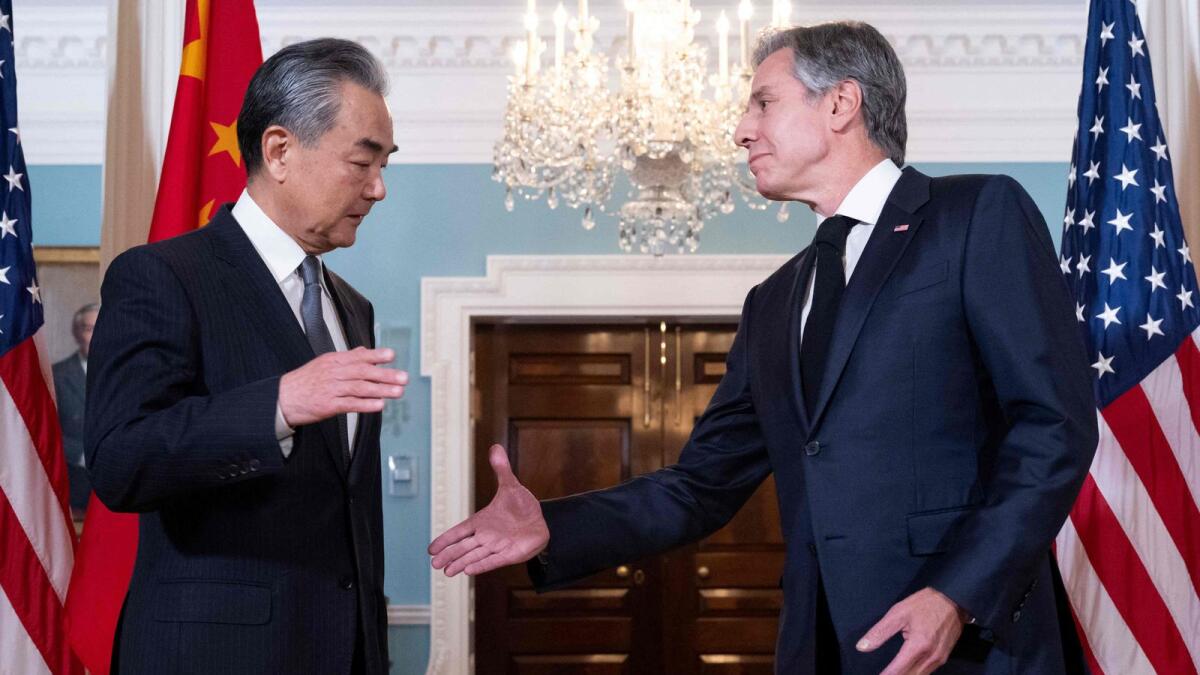 Antony Blinken shakes hands with Wang Yi in Washington, DC. — AFP
