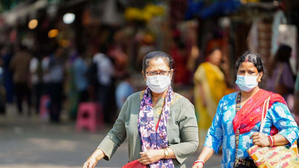Women wearing masks amid rise in Covid-19 cases, cross a road at Connaught Place in New Delhi on April 2, 2023. — PTI