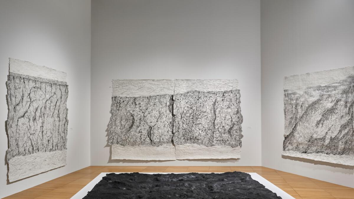 Installation view of Blane De St. Croix: Horizon at The NYUAD Art Gallery, 2023. Foreground: Lava Bed (from the Kilauea series), 2015 Background: Arctic Shoreline, Svalbard Archipelago (series), 2014–2015
