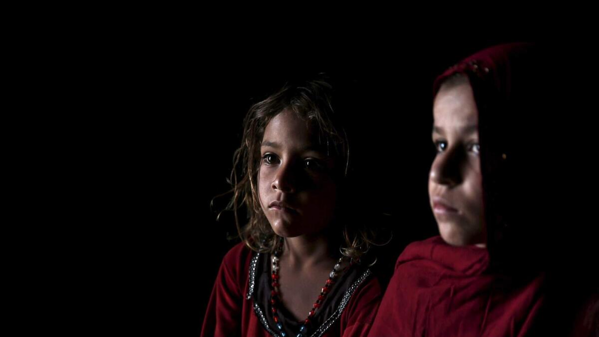 Afghan refugee children, returning from Pakistan, watch a short video clip about mines at a mines and explosives awareness programme at a UNHCR registration centre in Kabul.
