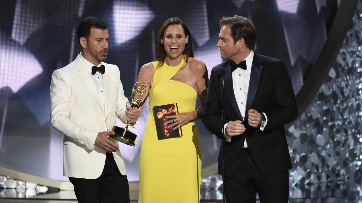 Host Jimmy Kimmel, left, takes the Emmy Award from presenters Minnie Driver, center, and Michael Weatherly after announcing Maggie Smith was the winner of the best supporting actress award for her role in 'Downton Abbey' at the 68th Primetime Emmy Awards on Sunday, Sept. 18, 2016, at the Microsoft Theater in Los Angeles. AP