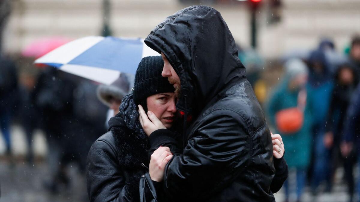 People comfort each other, as they observe a minute of silence commemorating the victims of the shooting in Prague on Saturday. Photo: Reuters