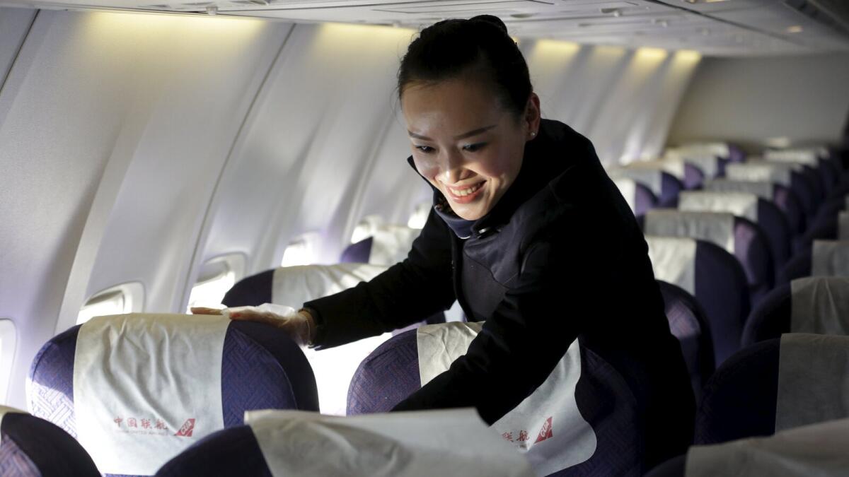 Chief flight attendant Han Juanjuan cleans the cabin of a China United Airlines aircraft after it landed at the Nanyuan Airport in Beijing, China, December 4, 2015.  REUTERS