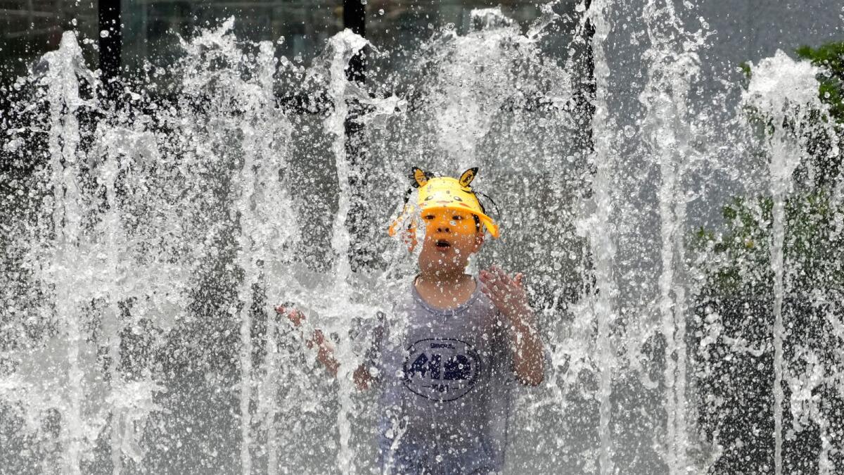 A boy cools off in a public fountain in Seoul, South Korea, Monday, June 19, 2023. A heat wave warning was issued in Seoul as temperatures soared above 34 degrees Celsius (93 degrees Fahrenheit) on Monday. -- AP