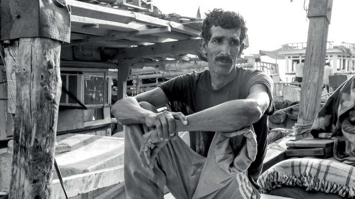 POWER IN PAIN... This Iranian crew member on a dhow agreed to be photographed only after a shared meal of fish and rice. He then lifted up his amputated leg and looked on with dignity.- Photo by Shihab