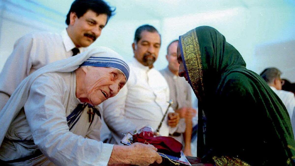 Mother Teresa presents documents for a new house to a villager from Latur in Bombay on September 26, 1994.