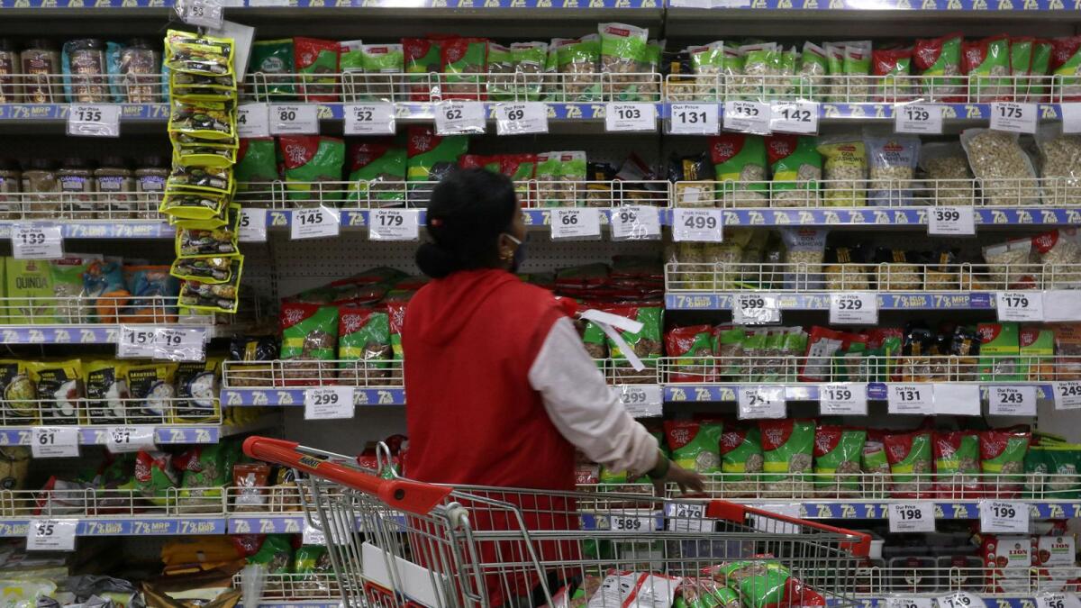 A worker arranges staple goods inside a Reliance supermarket in Mumbai. — Reuters file