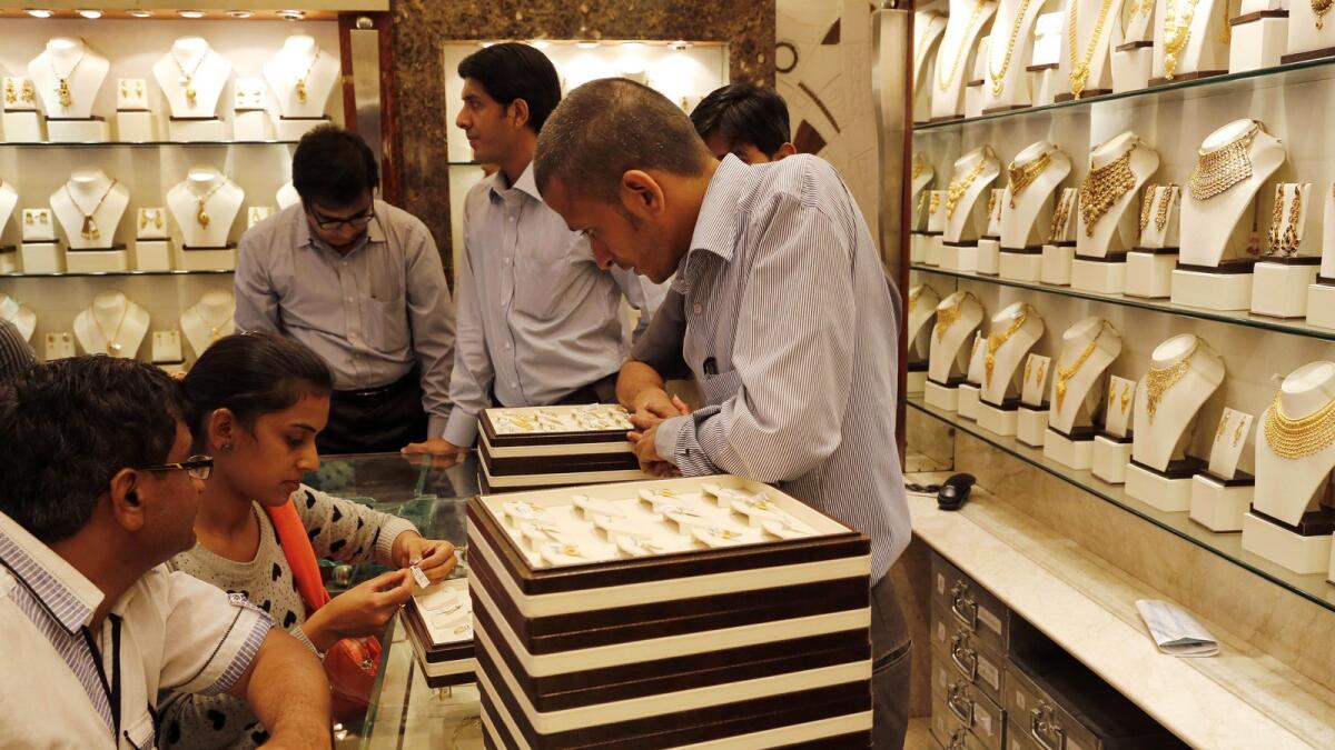 In this Friday, Dec. 6, 2013 photo, Indian customers look at gold jewelry at a shop in Mumbai, India. (AP Photo)