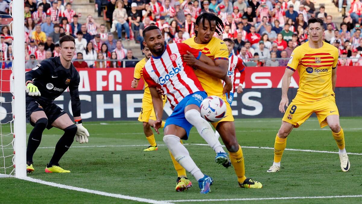 Girona's Yangel Herrerafights for control against FC Barcelona's Jules Kounde. - Reuters
