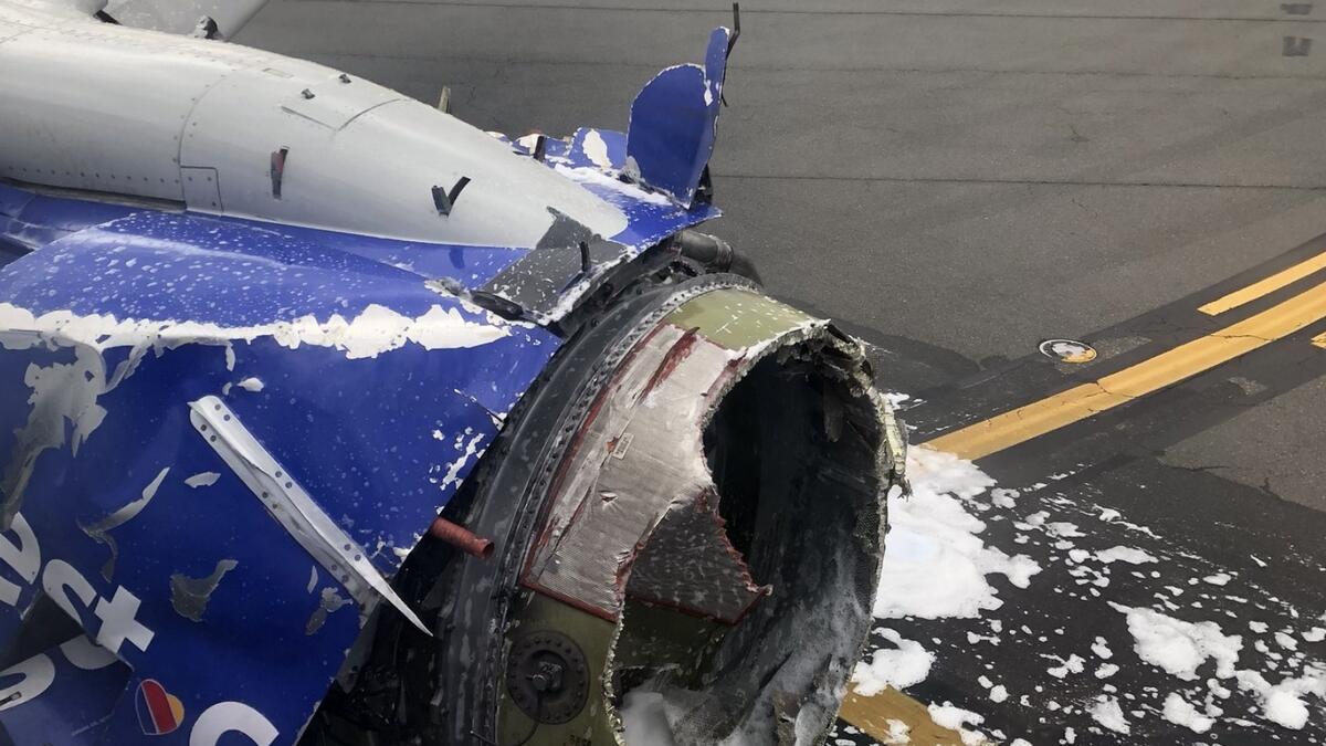 1 dead after jet blows an engine; woman nearly sucked out