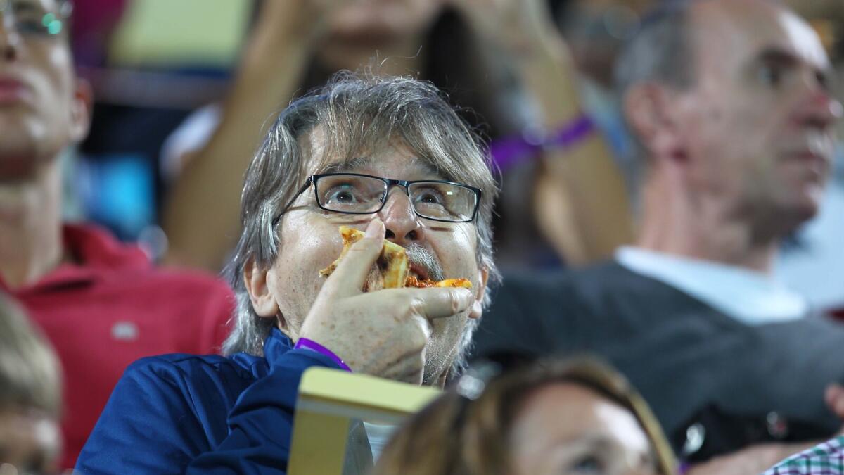 I AM HUNGRY AND IT'S PIZZA TIME... A spectator takes a pizza bite during the Novak Djokovic and Tommy Robredo match at the Dubai Duty Free Tennis Championships at Dubai Tennis Stadium on Monday, 22 February 2016. Photo by Kiran Prasad