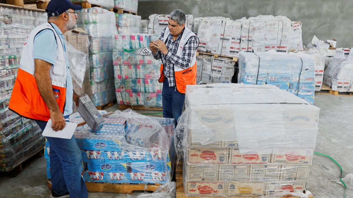 Red Crescent workers sort aid before being distributed to Palestinians. – Reuters