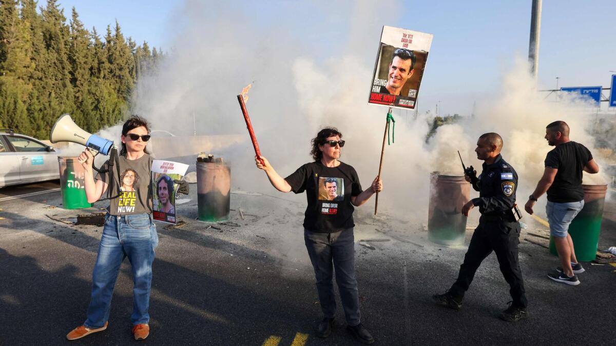 A woman holds a poster bearing the image of 43-year-old Israeli Dror Or as relatives and supporters of hostages block the Ayalon highway between Tel Aviv and Jerusalem on April 19. Photo: AFP file