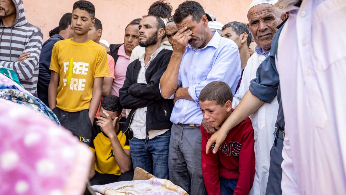 People mourn in front of the body of a victim killed in the earthquake in Moulay Brahim, Al Haouz province, on Saturday. — AFP