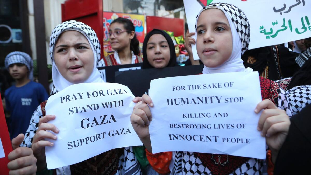 Palestinian students hold placards during a protest in solidarity with the Palestinian people in Lebanon on Wednesday. — AP