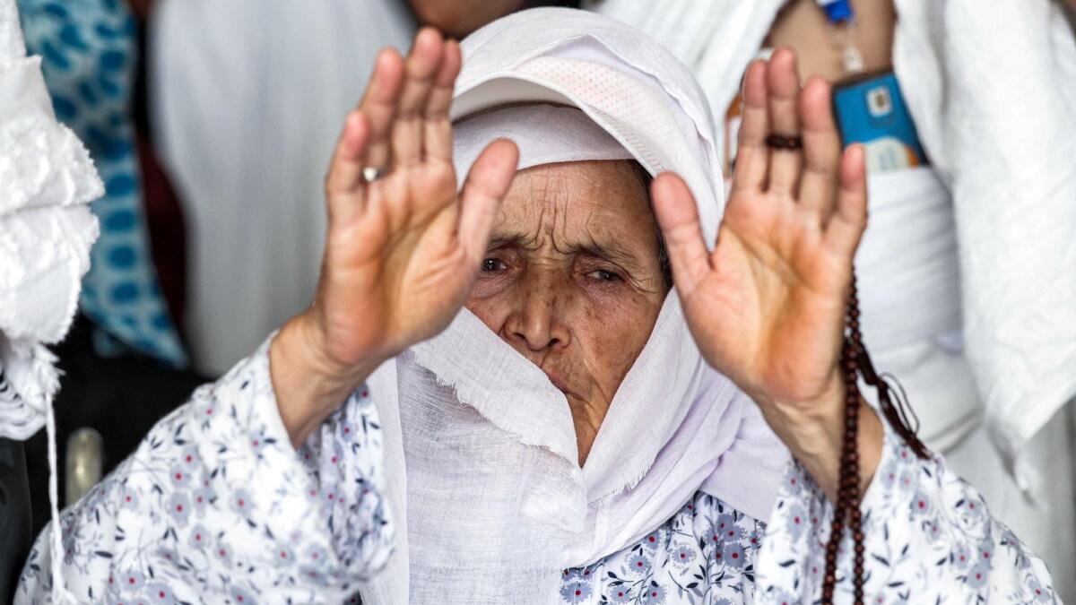An elderly woman prays at the Grand Mosque. — AFP