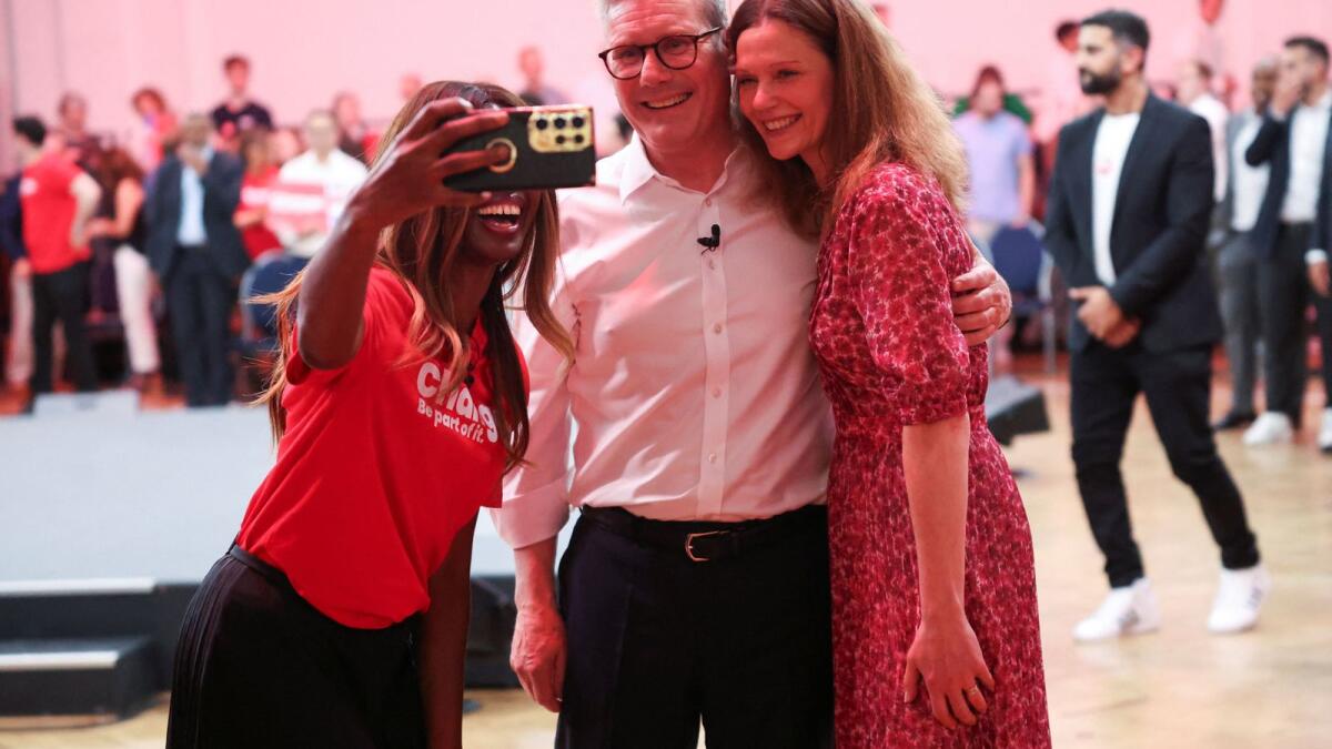 British opposition Labour Party leader Keir Starmer and Victoria Starmer pose with an attendee, during a general election campaign event at The Royal Horticultural Halls in London, Britain, on Sunday. — Reuters