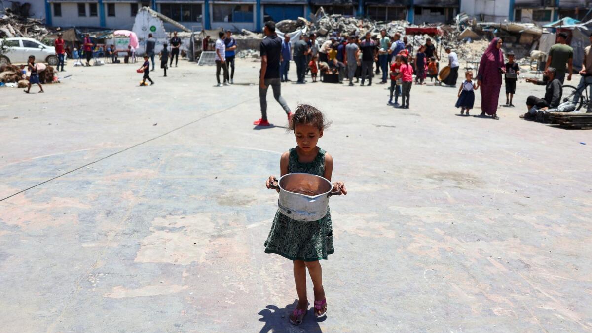 A child carries food at a UN Relief and Works Agency for Palestine Refugees (UNRWA) school in the Jabalia camp in the northern Gaza Strip. Photo: AFP file