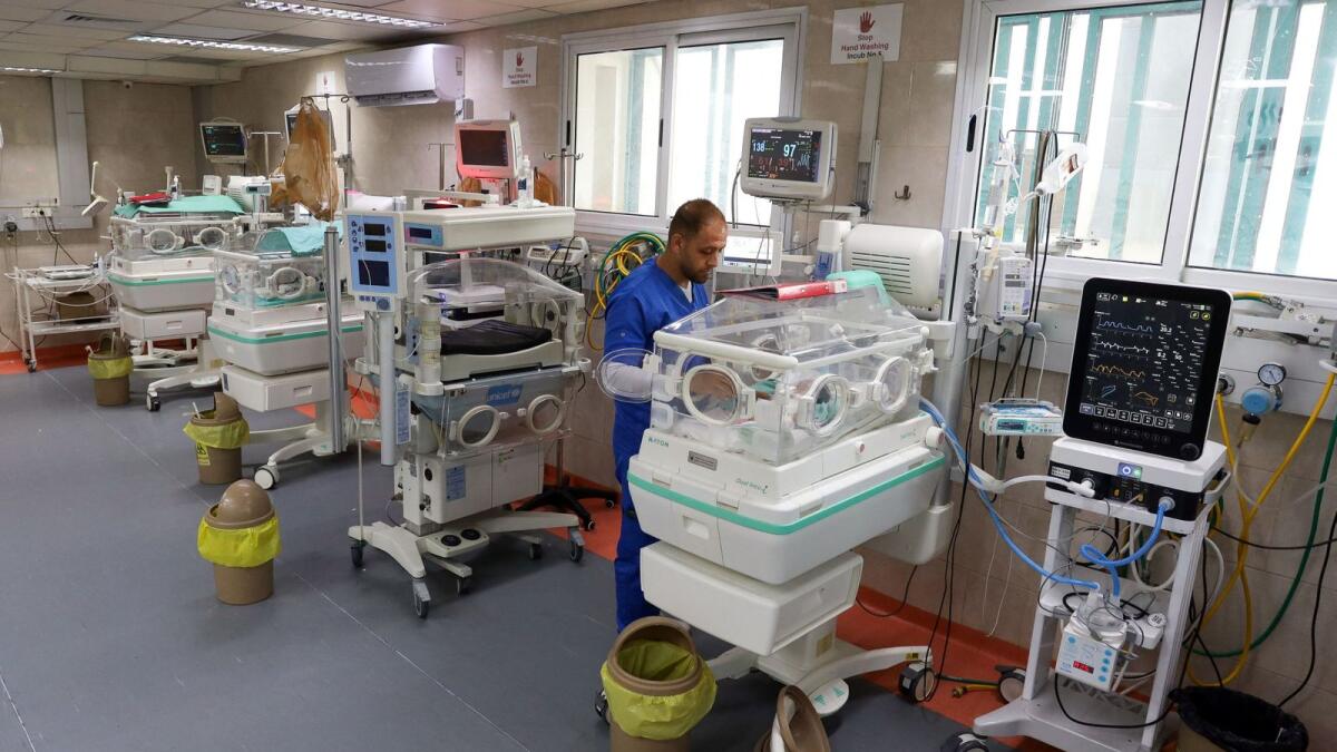 A medical worker assists a premature Palestinian baby who lies in an incubator at the maternity ward of Shifa Hospital, which according to health officials is about to shut down as it runs out of fuel and power. — Reuters
