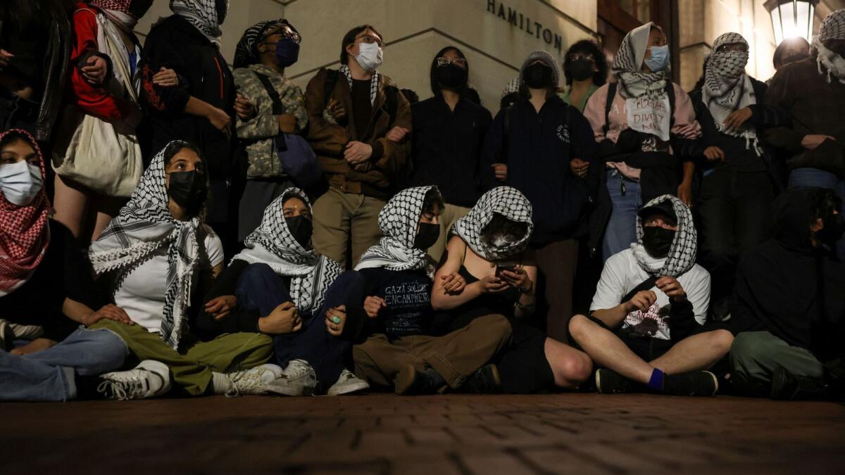 Protesters link arms outside Hamilton Hall barricading students inside the building at Columbia University despite an order to disband the protest encampment supporting Palestinians or face suspension in New York City on Tuesday. — reuters