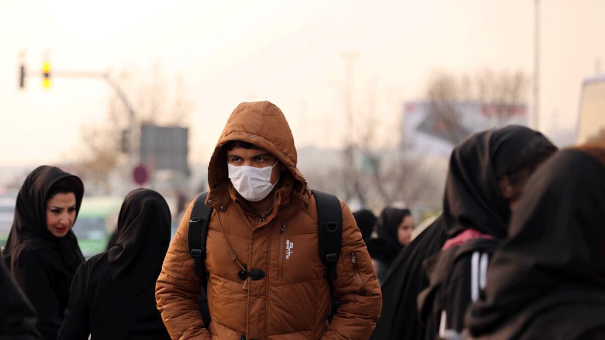 An Iranian schoolboy wears a facemask as he walks in a heavily polluted area in Tehran.