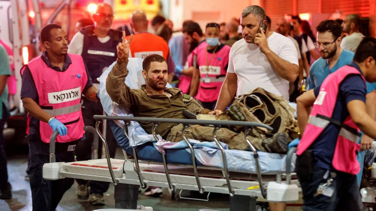 An injured Israeli officer gestures as he arrives at a hospital, following a mass-infiltration by Hamas gunmen from the Gaza Strip, in Ashkelon, southern Israel October 7, 2023. Reuters