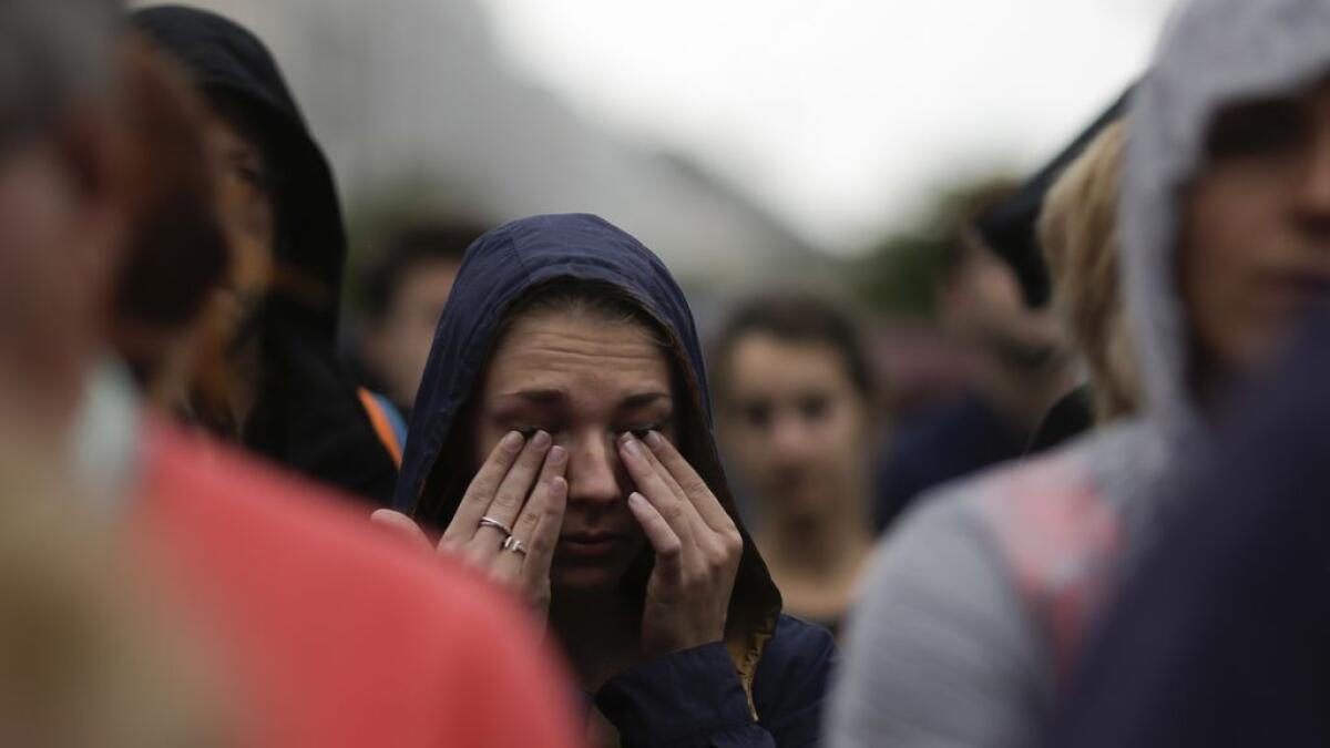 A woman weeps during an event to commemorate the victims of an attack in Nice near the French embassy in Berlin, Germany