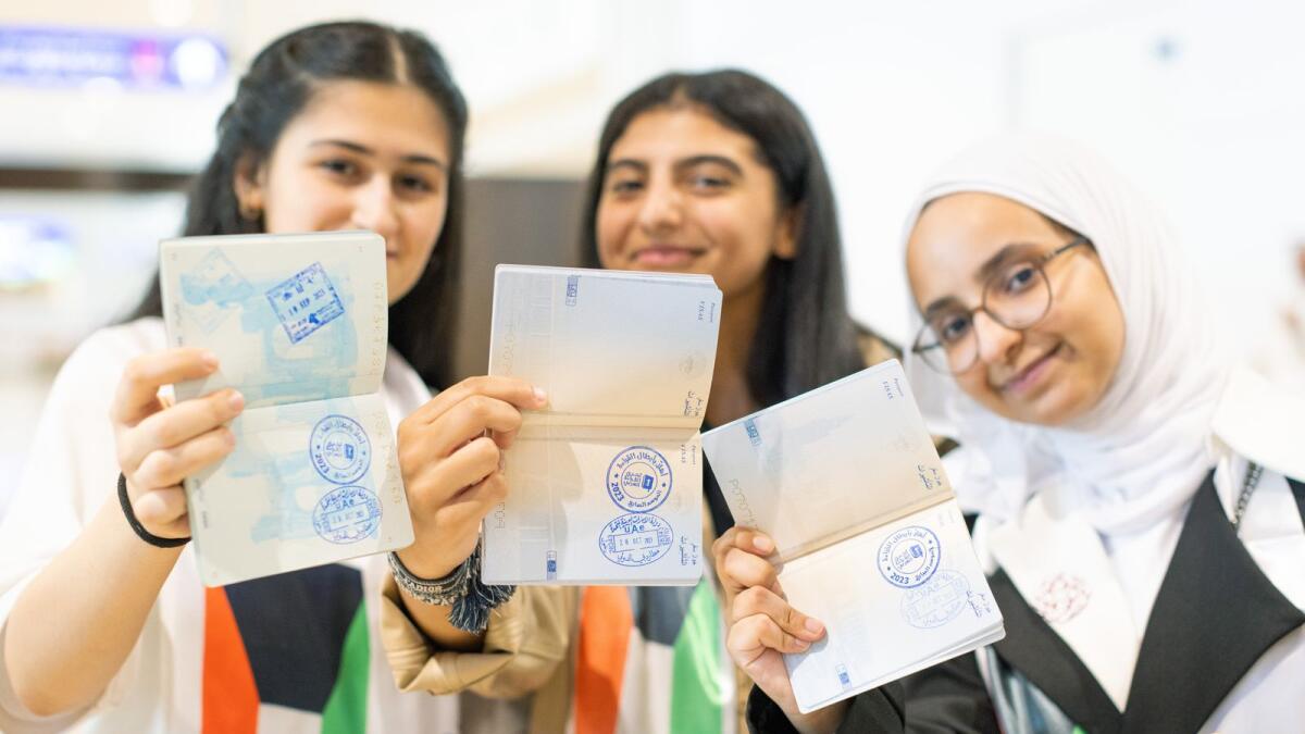 Arab Reading Challenge participants show the special entry stamp that features the Arab Reading Challenge logo on their passports.
