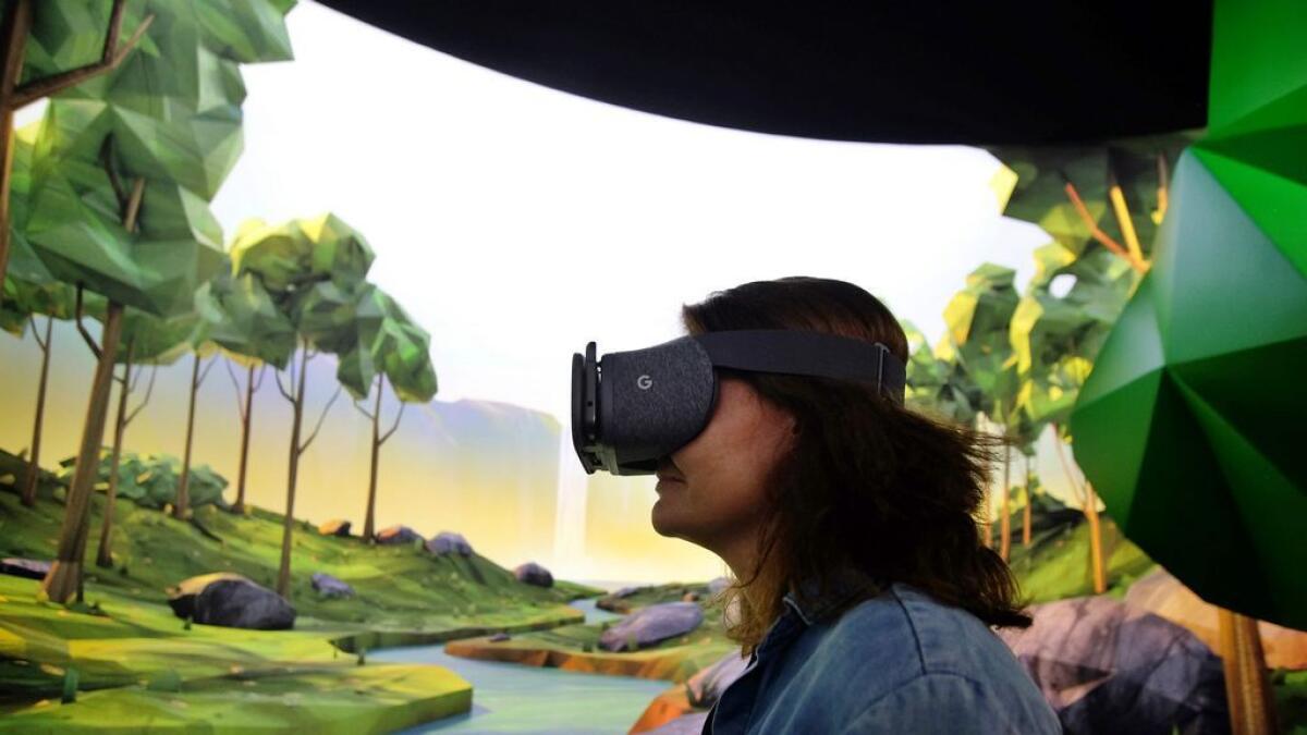 A woman tries on Google's virtual reality (VR) device 'Daydream View' - AFP file photo